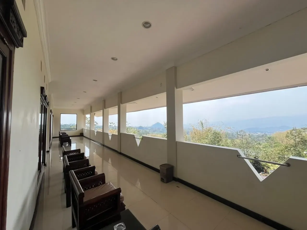 Koridor terbuka OAK Lawang dengan kursi kayu.